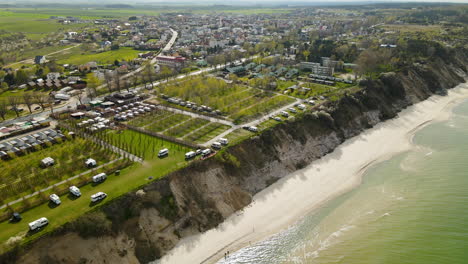 Campamento-De-Remolques-Para-Autocaravanas-En-Un-Acantilado-En-La-Playa-De-Chlapowo,-Polonia,-Sobrevuelo-Aéreo-En-Un-Día-Soleado