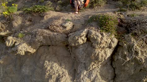 Woman-Reading-Book-on-Chair-on-Outdoor-Cliff---Rising-Aerial-reveal