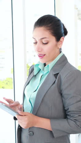 una mujer de negocios feliz usando una tableta.