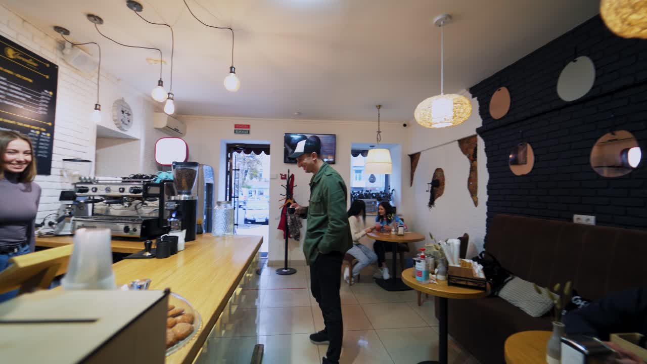 Woman offers to taste beverage. Coffee maker giving tasty coffee to visitor in cafe