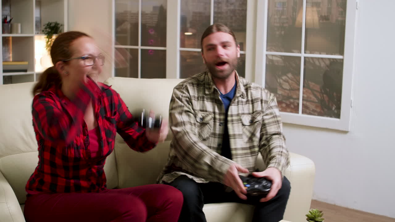 Couple playing video games and celebrating indoors