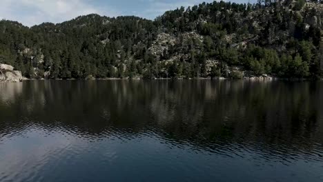 aerial view of a drone flying above a lake, near les bulloses, in la cerdanya, catalunya