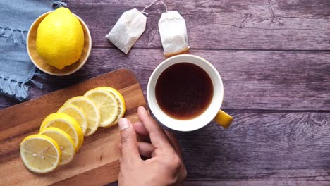 lemon tea and sliced lemon on a wooden cutting board