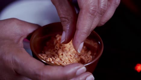 Woman-using-her-hands-to-Display-a-cup-of-yellow-dried-lentils-to-the-camera