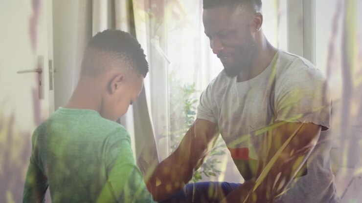 Animazione di erba su felice padre e figlio afroamericani che si vestono insieme