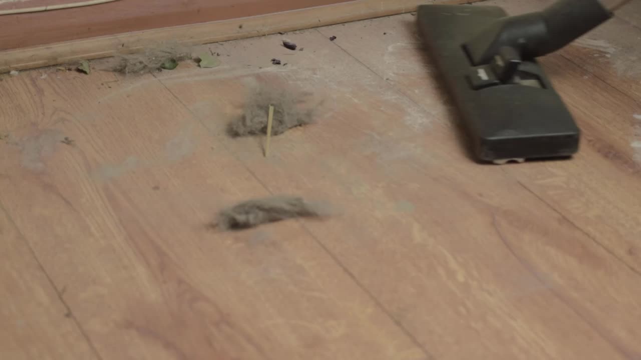 전기 진공 청소기로 더러운 먼지가 많은 바닥을 청소합니다.