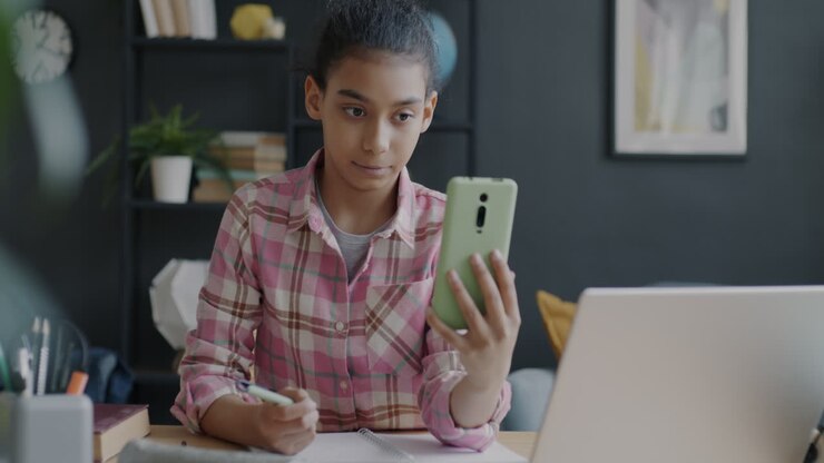 Girl Studying at Desk with Laptop and Smartphone