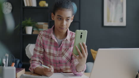 girl studying at desk with laptop and smartphone