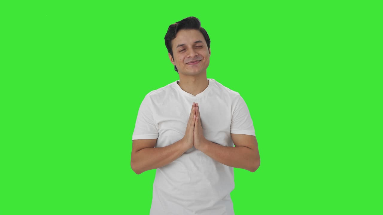 Happy Indian man doing Namaste Green screen
