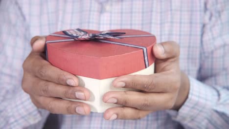 person holding a heart-shaped gift box