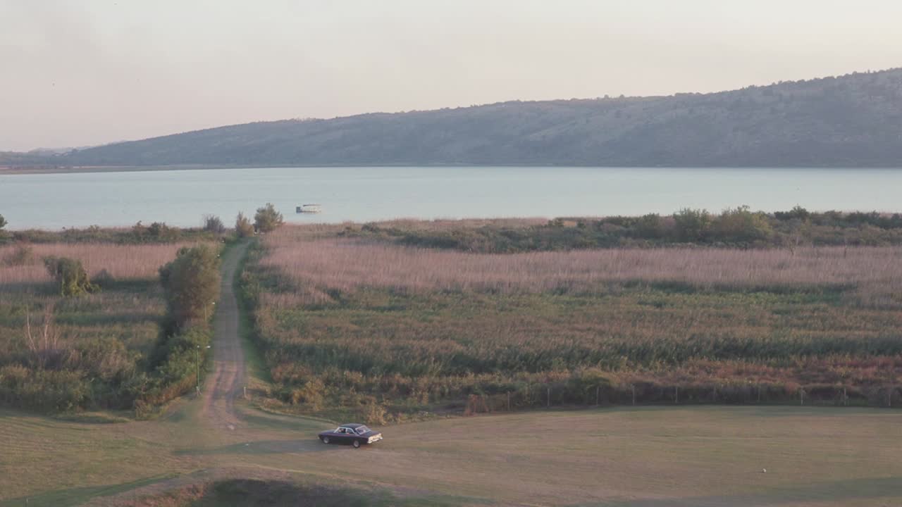 해가 지는 동안 호수 의 경치 좋은 시골 도로