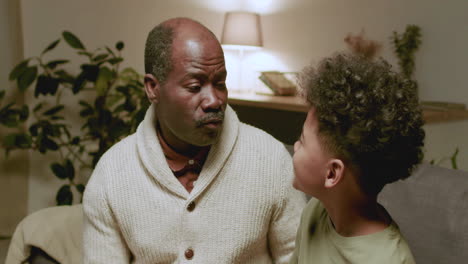 old black man and boy talking at home