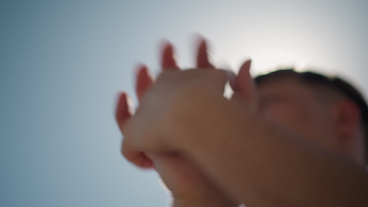 참가자가 팔을 하늘로 뻗고, 한 개인이 화창한 야외 환경에서 운동을 준비하며, 백인 스포츠인이 밝은 하늘을 머리 위에 두고 스트레칭 운동을 하고 있어요.