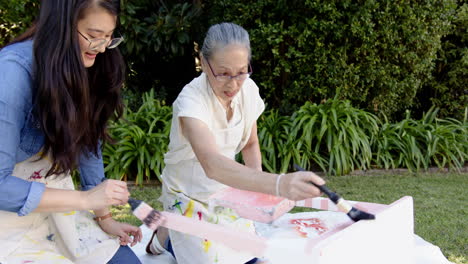 painting together outdoors, elderly woman and young woman enjoying creative activity