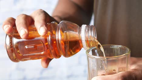 pouring tea from a bottle into a glass