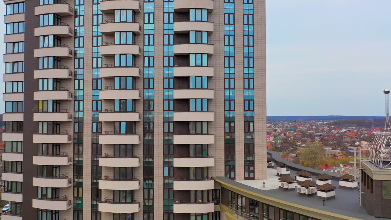 Multy-storey building with new design for high structure in the city. Aerial view of a beautiful high-rise public housing apartments. Camera moves right.