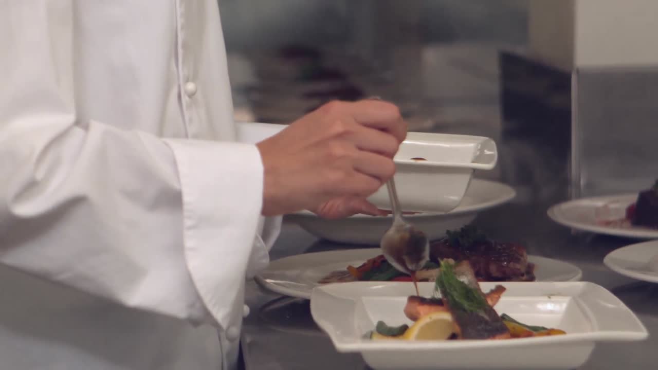 Chef che versa la salsa su un piatto di pesce
