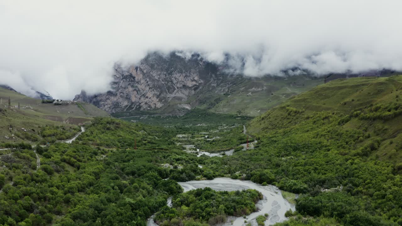 valle de montaña con río y nubes