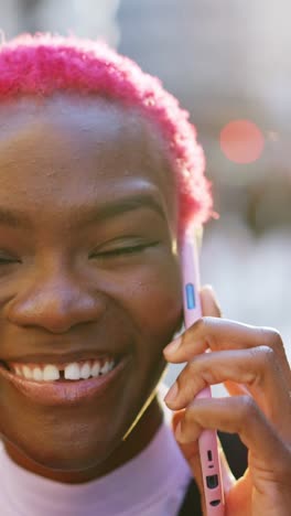 young woman with pink hair talking on a smartphone