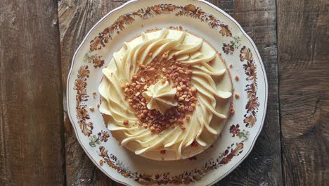 homemade cream cake with sprinkled nut topping on vintage plate