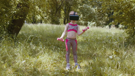 niño atlético en casco de auriculares vr haciendo ejercicios de entrenamiento de fitness con pesas al aire libre en el parque