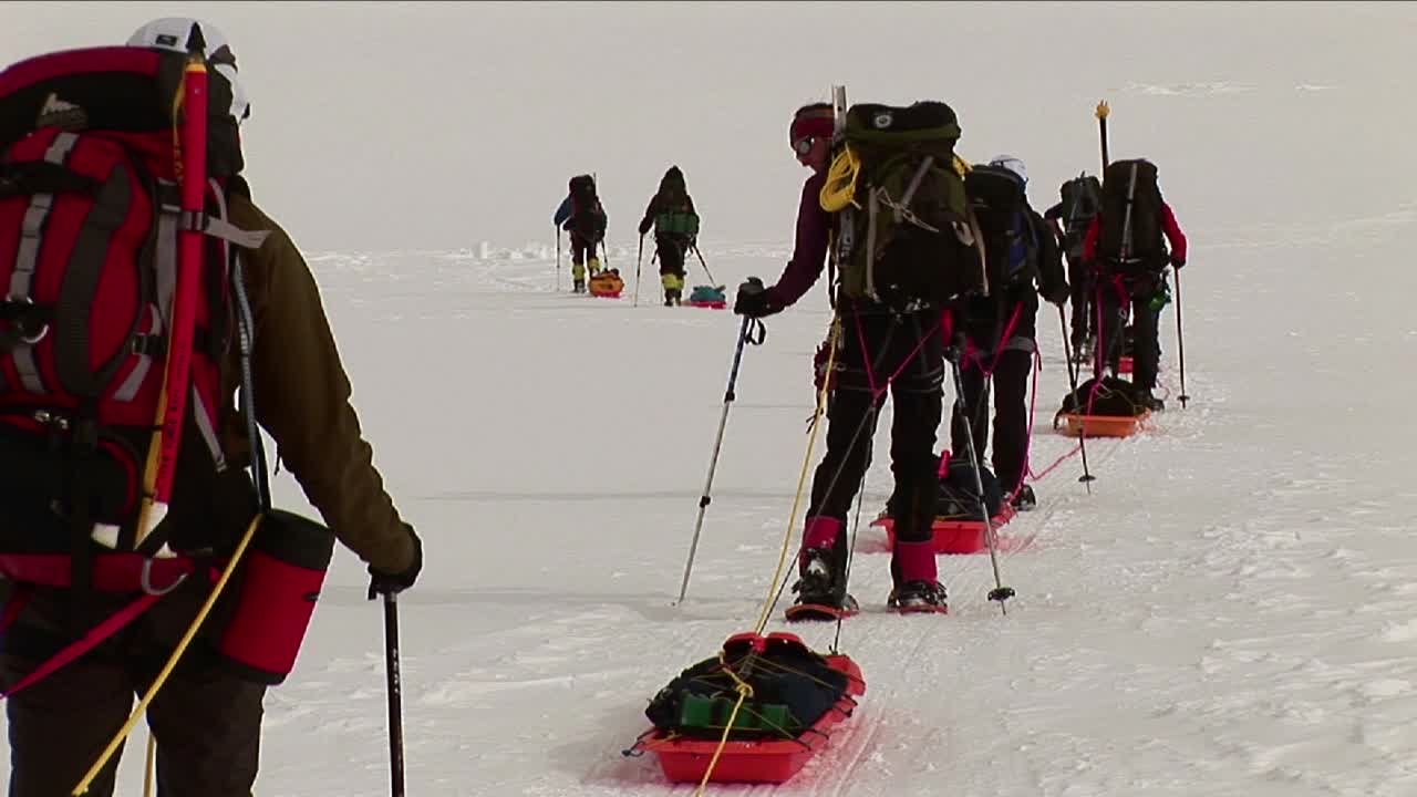 스노우 슈와 썰매를 타고 올라가는 등산객