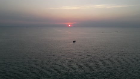 Traditional-longtail-boat-sailing-into-the-sunset-over-the-Gulf-of-Thailand-near-Pattaya