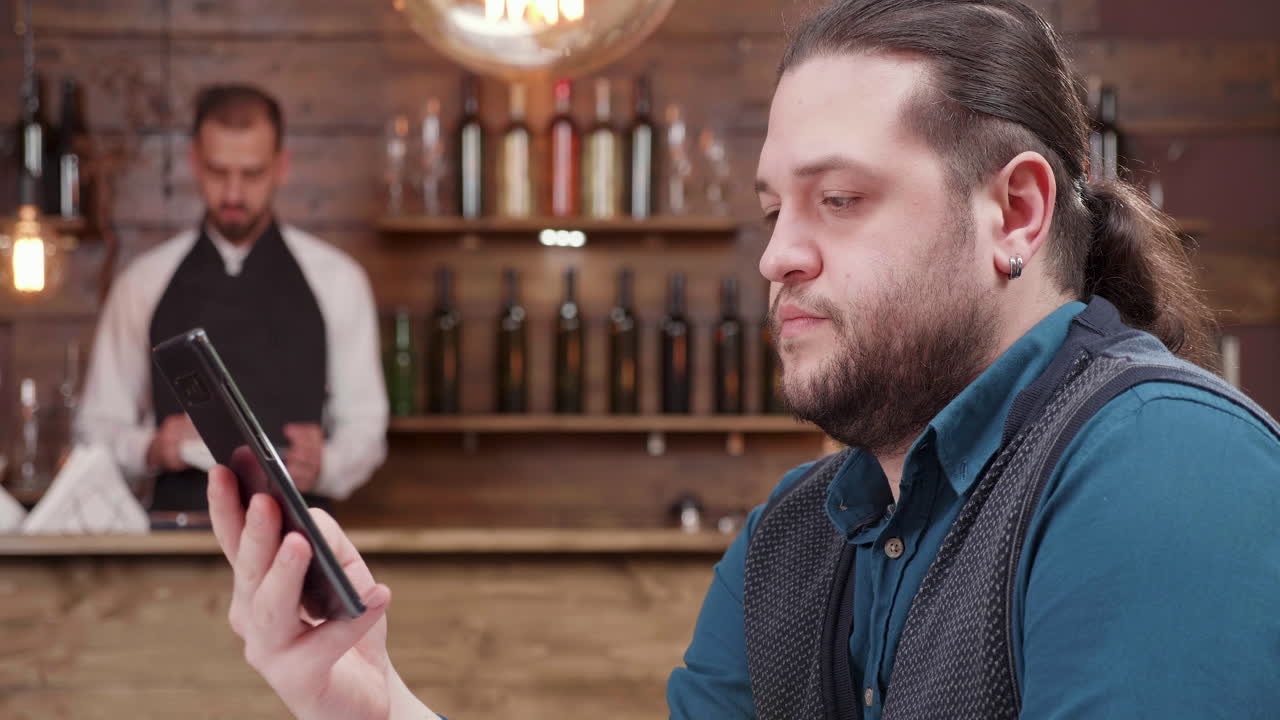 Man using smartphone in a bar