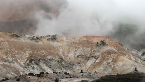 Vista-Calmante-E-Impresionante-De-La-Niebla-De-La-Pendiente-Ascendente-Detrás-De-La-Montaña-Rocosa-Y-Nevada,-Jigokudani,-Valle-Del-Infierno,-Plano-Todavía-Ancho