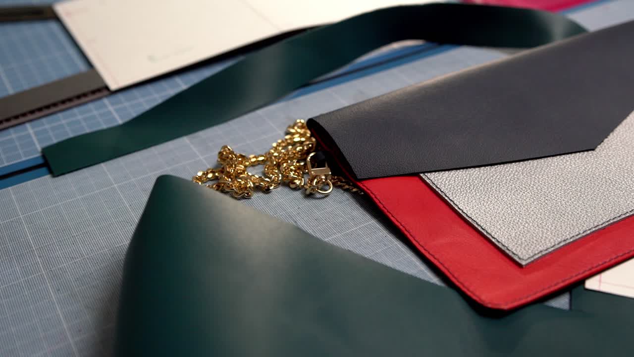 커팅 테이블 위의 체인 스트랩, 핸드헬드 궤도 샷 등 핸드백 제작을 위한 가죽 세그먼트