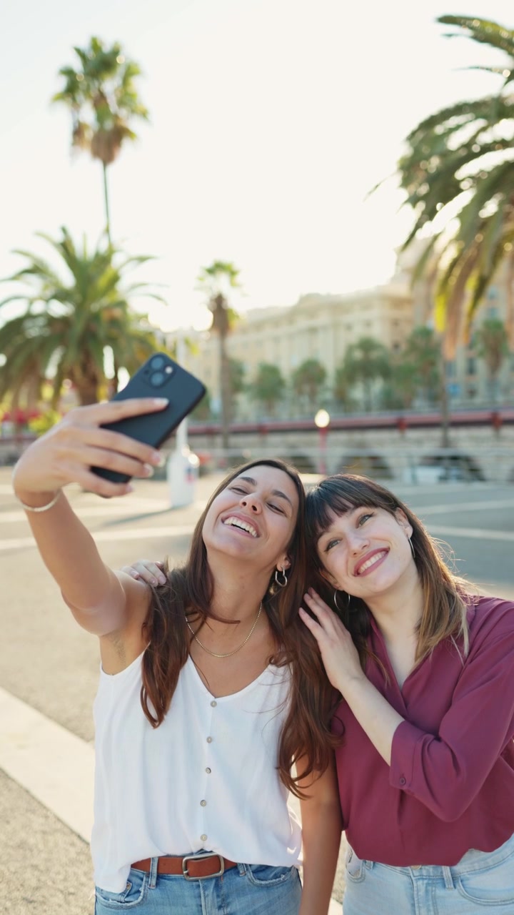 Giovani amiche felici che si scattano un selfie all'aperto con uno smartphone
