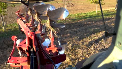 heavy tractor plowing land field on sunny day, view from inside