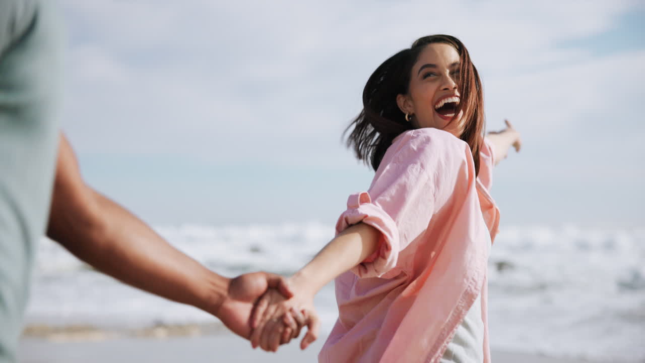 손을 잡고 해변을 고 있는 커플