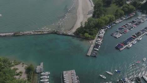 Imágenes-Aéreas-De-Las-Olas-Del-Lago-Michigan-Arrastrando-Una-Playa-Al-Norte-De-Chicago-Con-Barcos-Atracados-En-Un-Puerto-Deportivo