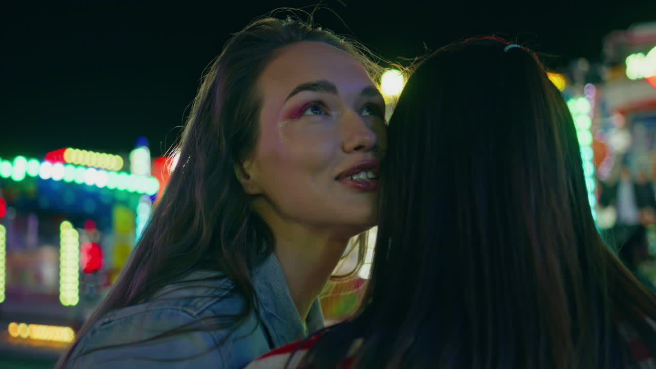 un primer plano de adolescentes alegres hablando en un parque de atracciones. amigos sonrientes descansando.
