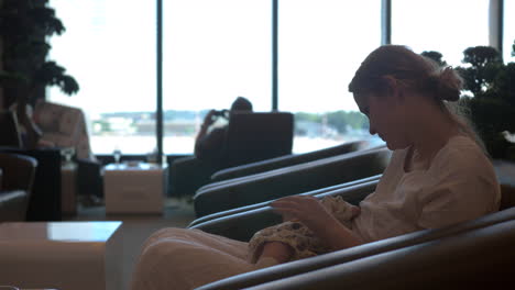 madre amamantando a su hija en la sala de espera del aeropuerto