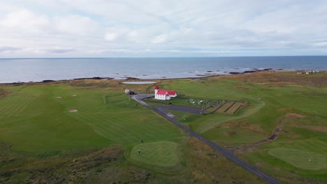 escena de la vida cotidiana, golfistas jugando en el campo de golf junto a la típica iglesia escénica, islandia