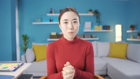 행복한 아시아 여성이 카메라를 향해 기 ⁇ 게 뭔가를 말하고 있습니다.