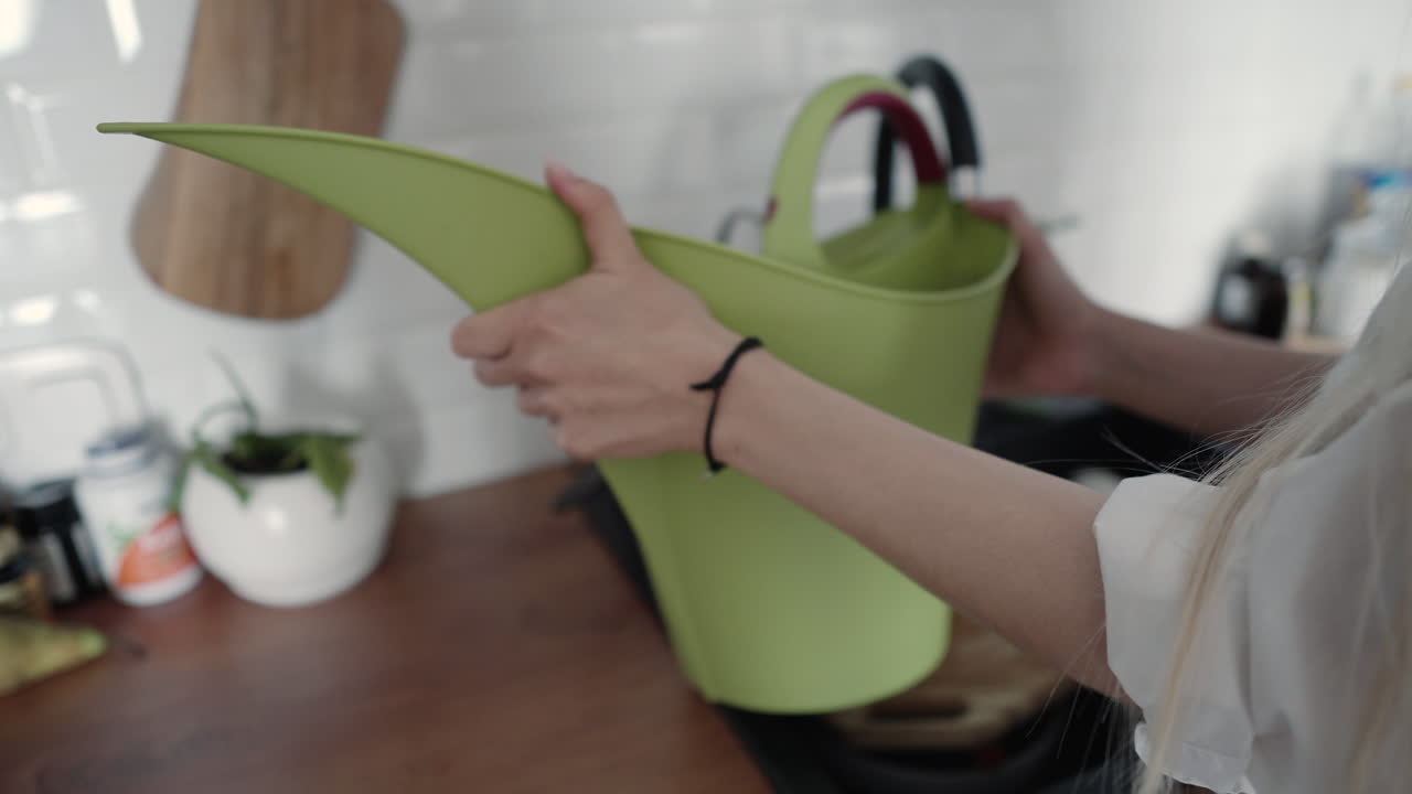 Woman watering plants in the kitchen