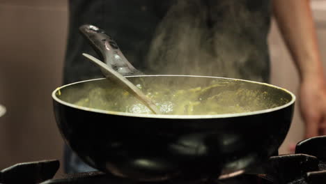 steam rising up from the sauce cooked on a sauce pan in the kitchen