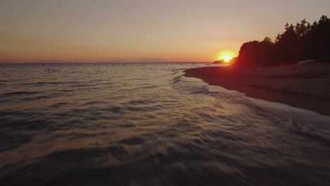 Fliegen-über-Den-Strand-Und-Das-Meer-Mit-Booten-Bei-Sonnenuntergang-Am-Strand-Von-Trikorfo,-Griechenland