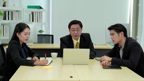 zoom out video of savvy supervisors are teaching younger employees in the office.