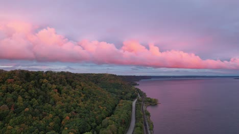 pink sunset over a river with autumn foliage