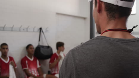 coach talking to rugby players in the locker room