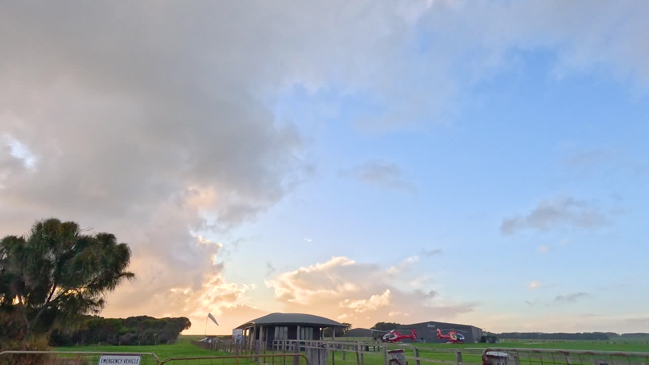 평화로운 농장 게이트 장면은 활기찬 일몰 하늘 아래 펼쳐져 조용한 시골 풍경과 열린 을 포착합니다.