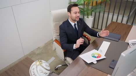 a professional man in a suit sits at a desk, celebrating success with clenched fists and a triumphant expression after studying a business report, creating a motivated and positive office atmosphere