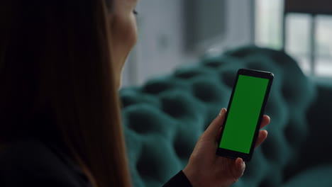 mujer de negocios agitando la mano en el teléfono de pantalla verde