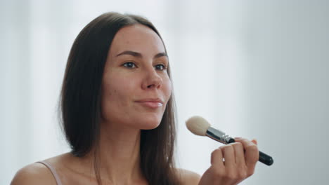 Mujer-Feliz-Aplicando-El-Primer-Plano-Del-Apartamento-En-Polvo.-Señora-Sonriente-Poniendo-Cosméticos