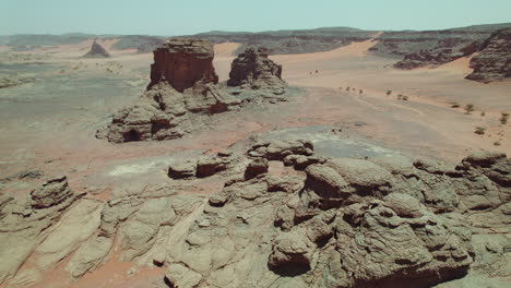 volando sobre formaciones rocosas naturales en los desiertos desolados de argelia, áfrica del norte