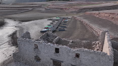 Building-ruin-and-unusable-pier-on-dry-shores-of-Sau-swamp-in-Catalonia,-Spain